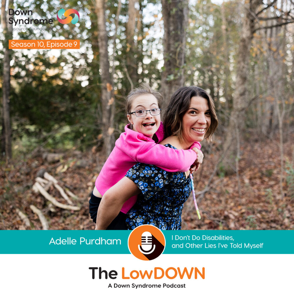 brown haired white woman wearing a blue shirt piggybacks her daughter, a white girl with Down syndrome with brown hair and glasses wearing a pink sweater, in the woods