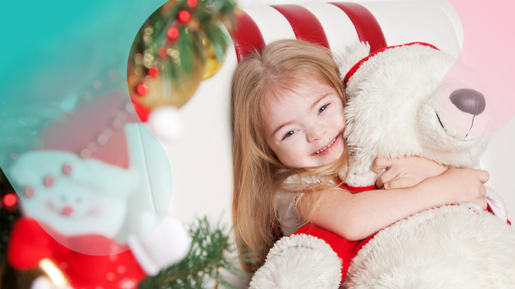 young white girl with Down syndrome with long blonde hair hugs a big white teddy bear wearing a Santa hat